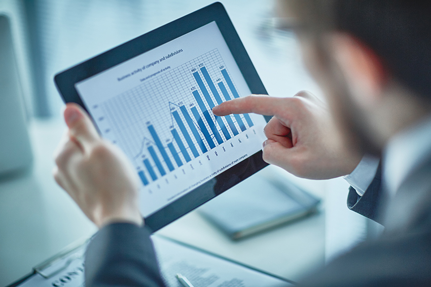 Businessman pointing at chart and graph in digital tablet
